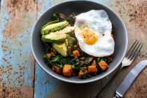 Gebratenes Ei mit Avocado und Grünkohl-Butternuss-Kürbis-Hasch — Stockfoto