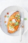 Baked sweet potato stuffed with cheddar cheese, spicy chickpeas, guacamole, yogurt and fresh mint — Stock Photo