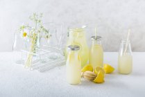 Homemade lemonade in a jug and serving bottles — Stock Photo