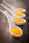 Raw eggs in a wooden spoon on a rustic background — Stock Photo