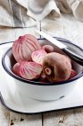 Chioggia beets, whole and halved in bowl - foto de stock