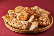 Различные печенье с ягодами, цитрусовые ломтики и орехи на тарелке — стоковое фото