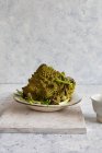 Molho pesto verde com sementes de gergelim e queijo em um fundo de madeira. — Fotografia de Stock
