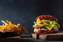 Burger with mango and avocado, served with fries — Stock Photo