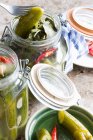 Pickled cucumbers in jar on wooden background — Stock Photo