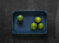 Limes in a wooden crate — Stock Photo