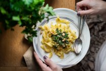 Female hands holding plate of Tagliatelle pasta — Stock Photo