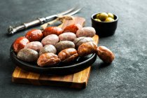 Spanish sausages on the cutting board (butifarra blanca, chorizo, morcilla de cebolla) — Stock Photo
