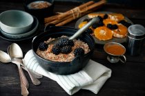 Wholegrain porridge with orange slices and blackberries — Stock Photo