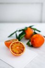 Blood oranges whole and halved on board — Stock Photo