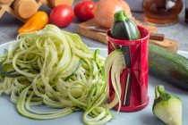 Zucchini-Nudeln mit spiralförmigem Gemüseaufschnitt zubereiten — Stockfoto