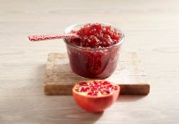 Homemade apple and pomegranate jam in jar and pomegranate half — Stock Photo