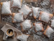 Beignets coated with powdered sugar and a cup of espresso — Stock Photo