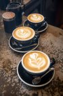 Cappuccinos con patrones de espuma de leche - foto de stock