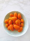 Свежие спелые мандарины в миске на белом фоне. — стоковое фото