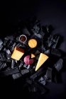Pedaços de queijo sentados em cima de carvão vegetal com uma pequena tigela de chutney — Fotografia de Stock