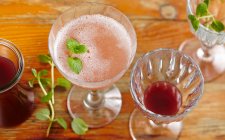 Prosecco and homemade fig syrup with mint in glasses on wooden surface — Stock Photo