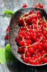 Fresh red currant in a bowl on a wooden background — Stock Photo