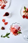 Kleine Erdbeer-Pavlovas mit Erdbeersoße beträufelt — Stockfoto