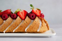 Gâteau de noix de coco avec glaçage, framboises et fraises — Photo de stock