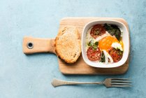 Яйцо с помидорами, базиликом и поджаренным хлебом — стоковое фото