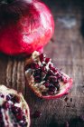 Fresh pomegranate fruits on rustic wooden background, close up — Stock Photo