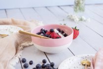 Йогурт з різними ягодами в рожевій мисці — стокове фото