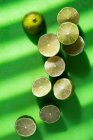 Nahaufnahme von köstlichen Limettenhälften auf einer grünen Oberfläche — Stockfoto