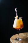 Помаранчевий коктейль з фруктами та соломинками в елегантному склі — стокове фото