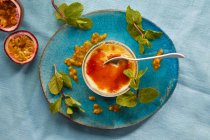 Creme brulee with passion fruit sauce and mint — Stock Photo