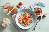 Portion of porridge with strawberries, honey and mint — Stock Photo