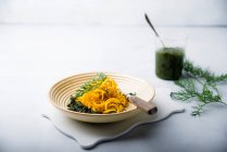Yellow carrot spirals with vegan pesto made form carrot leaves — Stock Photo