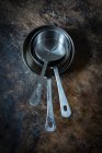 Various metal pans staked on rustic surface — Stock Photo