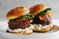 Burgers with grilled beef patties, cream cheese and spinach on classical bun — Stock Photo
