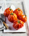 Tomates fraîches et basilic sur fond de bois — Photo de stock