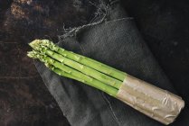A bundle of green asparagus on a linen cloth — Stock Photo