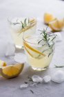 Limonata con limoni e rosmarino in bicchieri sul tavolo — Foto stock