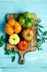 Fresh tomatoes and basil on a wooden background — Stock Photo