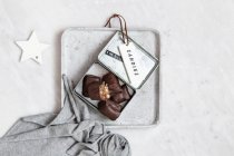 Chocolate candy with nuts and dates in gift box on white marble background — Photo de stock