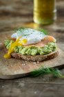 Bread topped with avocado cream, salmon and a poached egg — Stock Photo