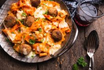 Gratinated tagliatelle with chickpea balls, tomato sauce and almond cheese — Stock Photo