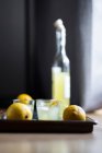 Limoncello with ice cubes and fresh lemons peel — Stock Photo