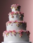 Celebrações da Páscoa, bolo de casamento branco em camadas com flores açucaradas caindo — Fotografia de Stock