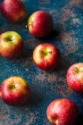 Fresh red apples on rustic surface — Stock Photo