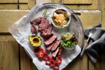 Филе говядины с овощами и салатом на желтом деревянном фоне — стоковое фото
