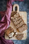 Sauerteigbrotscheiben auf Holzbrett mit Tuch — Stockfoto