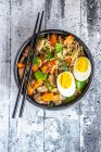 Раменный суп с овощами, грибами, копченым тофу и яйцом — стоковое фото