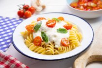 Pasta with mozzarella sauce and cherry tomatoes — Stock Photo