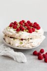 Torta Pavlova con pistacchi e lamponi servita sul tavolo — Foto stock