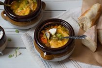 Смешанный овощной суп подается в глиняных горшках, увенчанный жареным сыром и хлебными тостами — стоковое фото